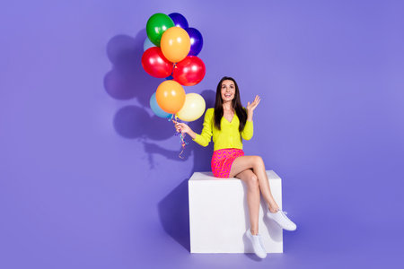 Photo of cheerful charming nice woman wear stylish clothes look up empty space isolated on purple color backgroundの写真素材