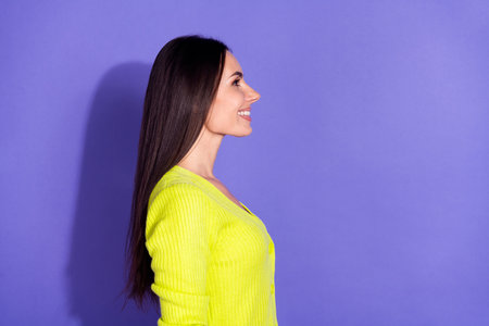 Profile side photo of lovely gorgeous girl wear trendy clothes look empty space isolated on purple color backgroundの写真素材