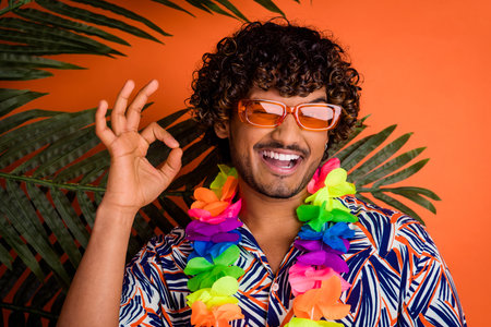 Photo of handsome man show okey enjoy summer palm leaves dressed stylish colorful garment isolated...