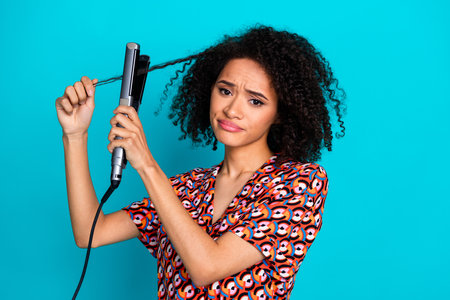 Photo of unhappy upset lady dressed print shirt straighten hair curls isolated turquoise color backgroundの写真素材