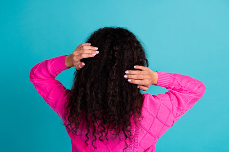 Rear photo of lovely young girl hands touch hair wear pink pullover isolated on teal color...