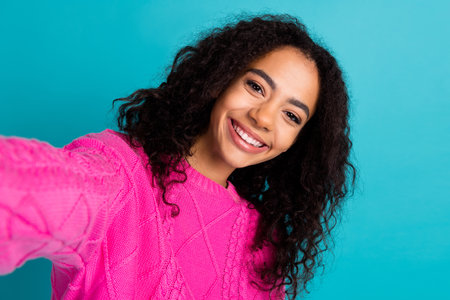 Photo of lovely young girl make selfie wear pink pullover isolated on teal color backgroundの写真素材