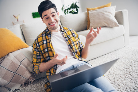 Photo of funky positive man wear checkered shirt staying home video call modern device indoors house...