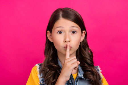 Photo of kid girl put finger lips silent sign isolated bright color backgroundの写真素材