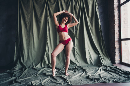Unretouched photo of girl posing raise hands feel body positive in studio backgroundの写真素材