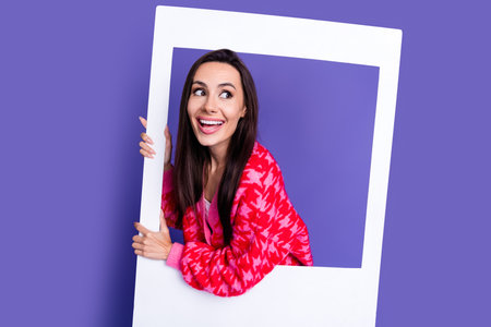 Photo of tricky attractive lady dressed pink cardigan holding paper photo frame looking empty space...