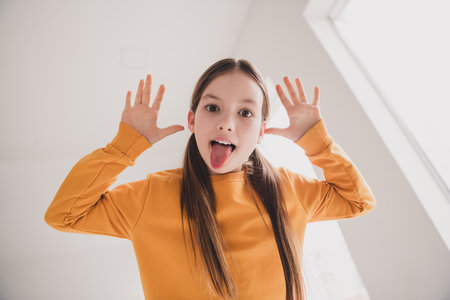 Photo of cute schoolkid have good mood play wear orange pullover pastime apartment indoors