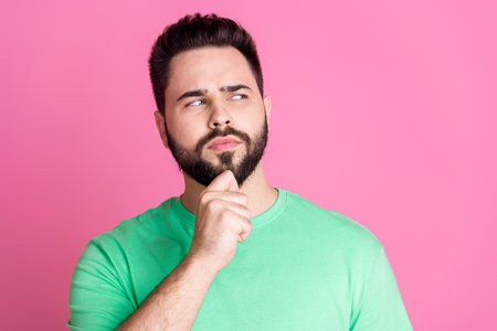 Photo of minded clever guy with stylish beard dressed green t-shirt look at proposition empty space...