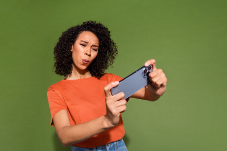 Photo portrait of lovely young lady play mobile game dressed stylish orange garment isolated on...
