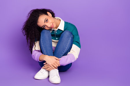 Full size photo of nice young girl sit floor empty space wear shirt isolated on violet color...