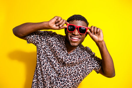 Photo of cheerful positive glad man wear stylish clothes hold sunglass isolated on vivid yellow...