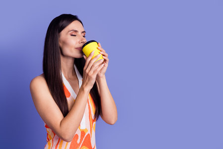 Photo of sweet shiny lady wear dress enjoying beverage closed eyes emtpy space isolated violet color backgroundの写真素材