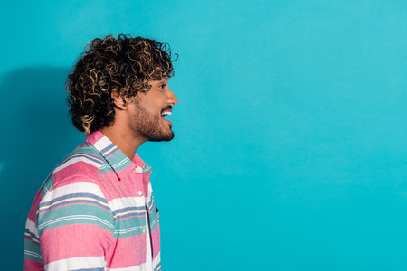 Profile photo of excited positive man wear stylish striped clothes announce news look empty space isolated on cyan color backgroundの写真素材