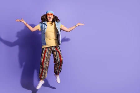 Full body photo of attractive senior woman jump raise hands dressed stylish jeans hipster clothes...