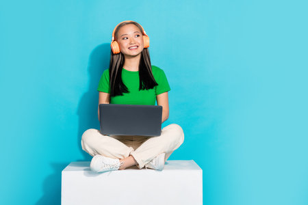 Full size photo of nice young girl sit podium look empty space wear t-shirt isolated on teal color backgroundの写真素材
