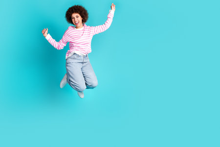 Full length portrait of nice young lady jump raise fists wear pullover isolated on turquoise color...