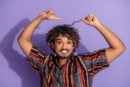 Photo of good mood man with beard wavy hairstyle dressed print shirt indicating at curl on head...