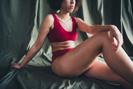 Cropped photo no filter of girl plus size sit posing isolated green color linen backgroundの写真素材