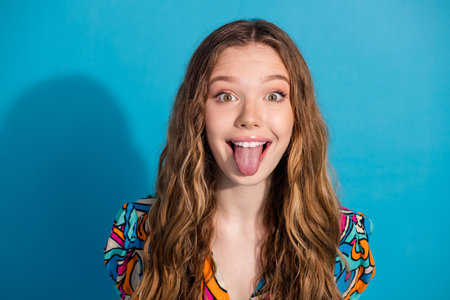 Portrait of nice young girl show tongue wear top isolated on turquoise color background