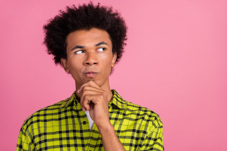 Photo of nice young man look empty space ponder wear shirt isolated on pink color backgroundの写真素材