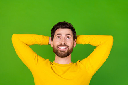 Photo portrait of attractive young man sleepy look up empty space dressed stylish yellow clothes isolated on green color backgroundの写真素材