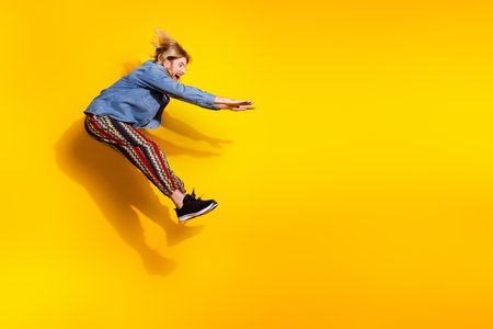 Full body photo of attractive young man jumping pushing invisible things dressed stylish denim...