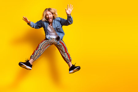 Full body photo of attractive young man falling down scared dressed stylish denim clothes isolated...