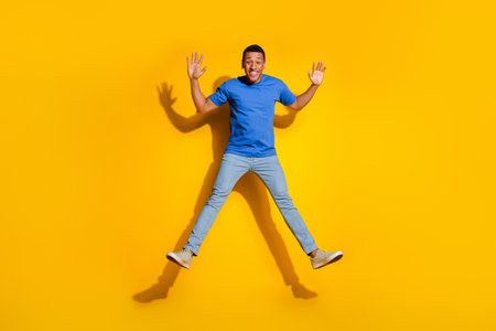 Full length photo of handsome young guy jump wave hands dressed stylish striped garment isolated on...