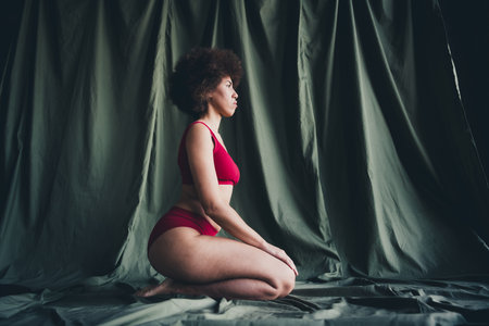 Unretouched photo of girl sit knees profile side isolated khaki linen backgroundの写真素材