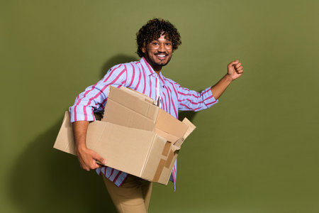 Photo of good mood guy with wavy hair dressed striped shirt in glasses hold rubbish go empty space...