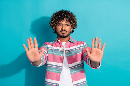 Photo of upset irritated man wear trendy striped clothes showing palms stop isolated on cyan color...