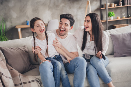 Photo of laughing charming mom dad children wear casual outfits watching funny tv show indoors room...