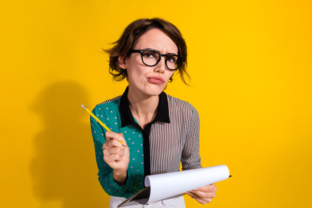 Photo of lovely minded woman wear stylish clothes hold paper list isolated on yellow color backgroundの写真素材
