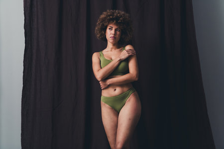 Photo of lovely young lady hug self look empty space dressed khaki lingerie studio background no filter self acceptance all body perfectの写真素材