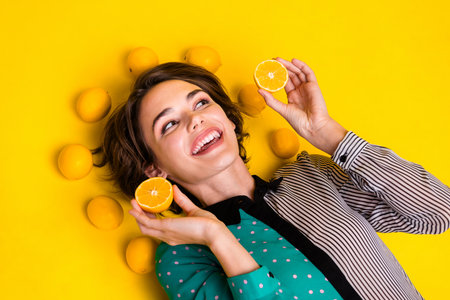 Photo of adorable cheerful nice woman wear stylish clothes hold lemons look empty space isolated on...