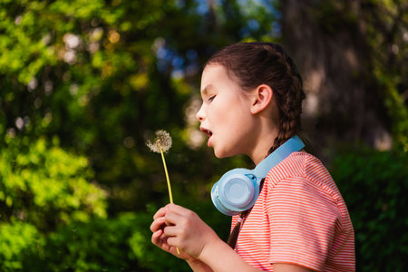 Portrait of charming lovely little girl summer play outside blow dandelion flower have fun good mood...