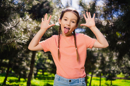 Portrait of positive cheerful happy little girl smile summer good mood playful have fun weekend enjoy outdoors outside park streetの写真素材