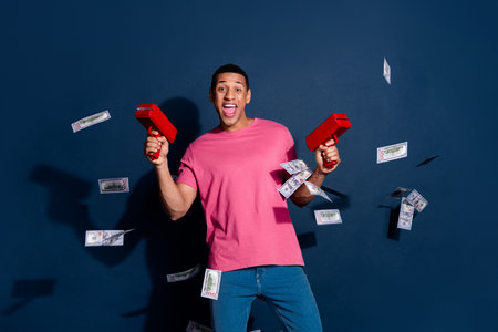 Photo portrait of successful wealthy crazy guy in casual outfit shooting cash with money gun...