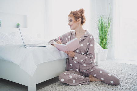 Photo of charming lovely woman wear trendy pajama weekend at home use modern gadget notebook daylight indoorsの写真素材
