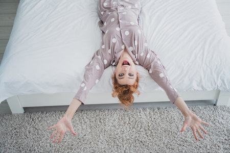 Top view photo of pretty cheerful lady sleepwear smiling having rest bedroom indoors home houseの写真素材