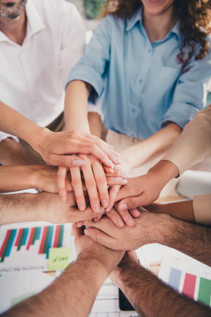 Vertical cropped photo of group business company workers pile stack handshake modern loft interior office indoorsの写真素材