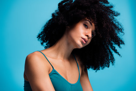 Photo of attractive girl with curly hair look feel tempting isolated blue color background
