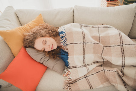 Photo of attractive trendy young woman lying sofa sleeping blue shirt move new apartment home interior indoorsの写真素材
