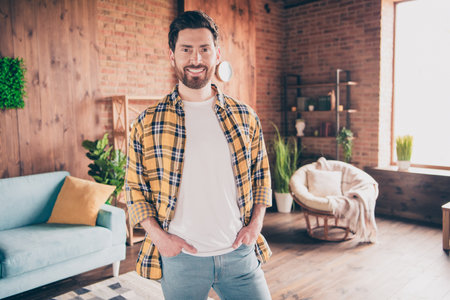 Photo of funky cool guy dressed checkered shirt smiling relaxing home indoors house apartment roomの写真素材