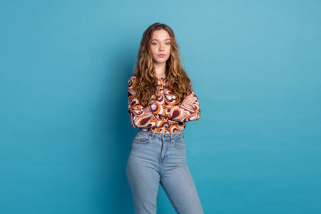 Photo of shiny attractive lady dressed retro shirt arms crossed empty space isolated blue color backgroundの写真素材