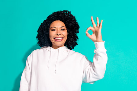 Photo portrait of young funny chevelure hairstyle lady wearing white hoodie good job symbol okey isolated on aquamarine color backgroundの写真素材