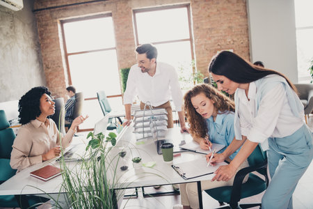 Photo of talking idea teamwork young people working together employees modern industrial open space...