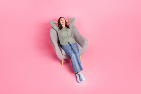 Top view full length photo of dreamy attractive lady dressed striped blouse relaxing arms behind head empty space isolated pink color backgroundの写真素材