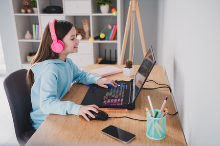 Photo of cheerful nice lovely girl playing online video game modern technology indoors