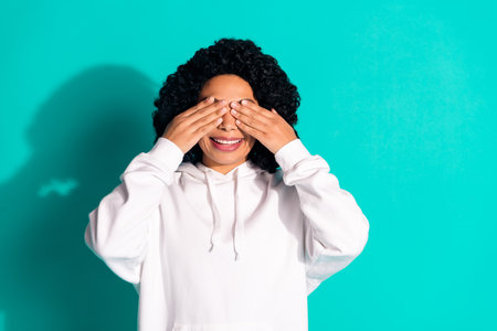 Photo portrait of young funny chevelure hairstyle lady wearing white hoodie playing hide seek game isolated on cyan color backgroundの写真素材